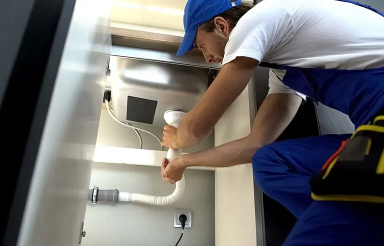 An emergency plumber testing low residential water pressure using a pressure gauge attached to an outdoor hose bib during an Arizona summer heatwave.
