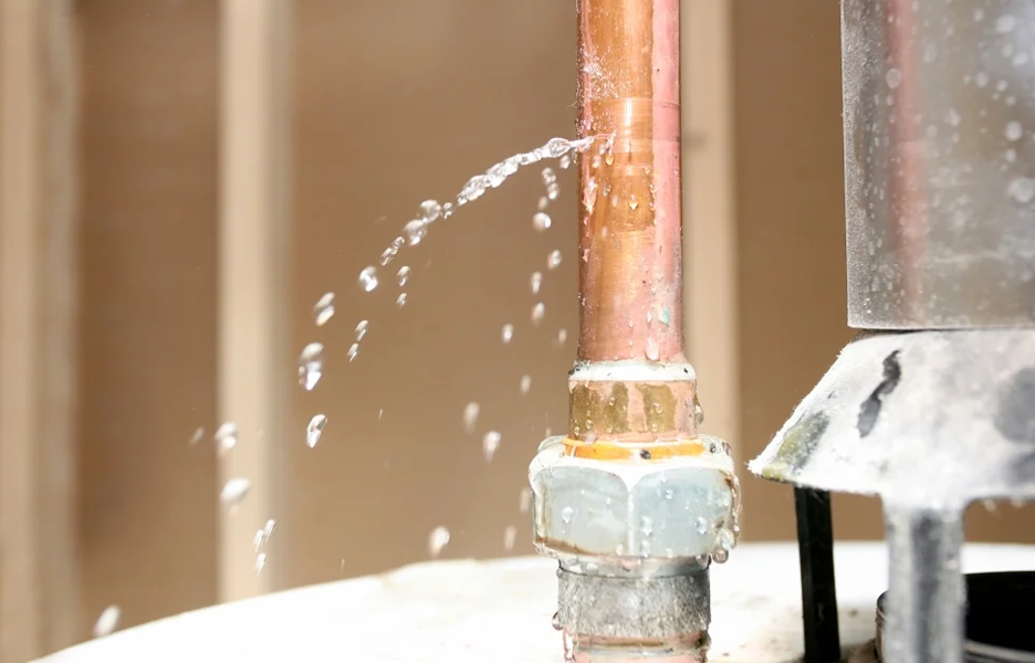 A professional technician installing a water pressure reducing valve on a residential main line to prevent pipe leaks caused by Arizona summer heat.