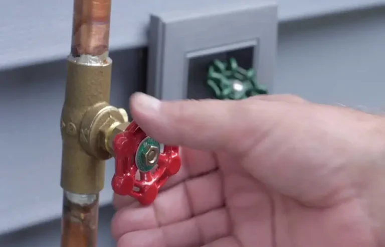 Homeowner closing a residential main water ball valve on an exterior copper pipe riser in Phoenix Arizona
