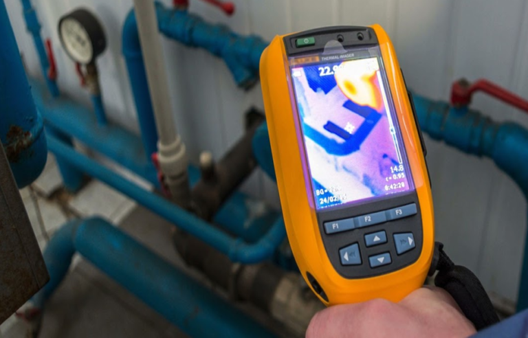 A professional plumber using acoustic ground microphones and smart leak detection equipment to locate a subterranean slab leak under a concrete floor in Phoenix.